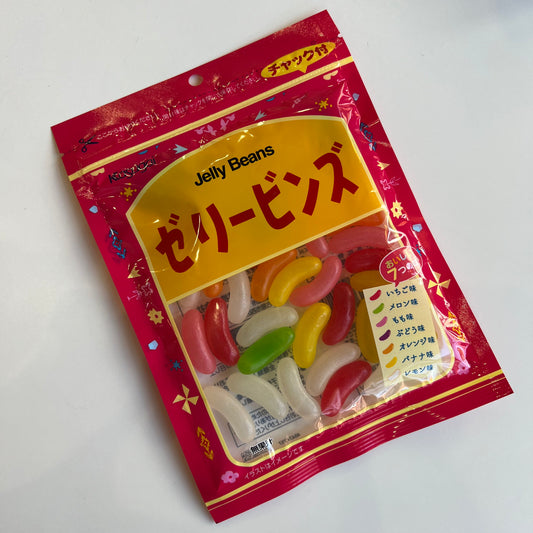 Jelly bean candy in multi colors in a red baggie with japanese writing. 